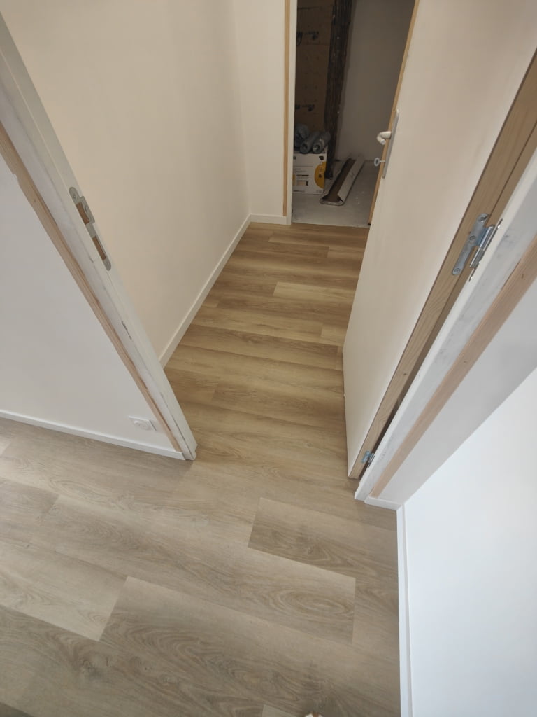 Chantier entièrement rénové Pose d'isolant thermique TMS chape liquide fluide ciment revêtement PVC souple collé imitation bois passage intensif plinthe médium